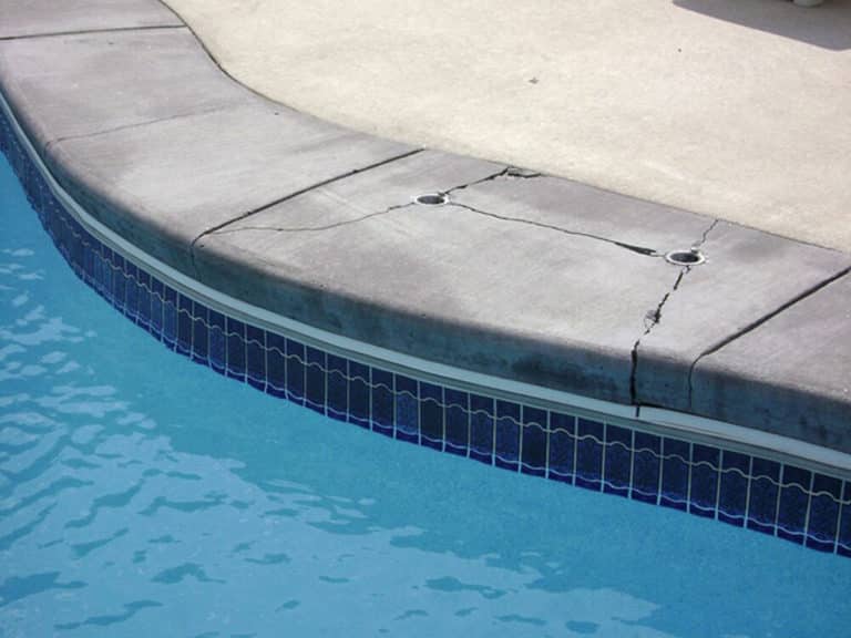 Concrete pool with cracks in it.