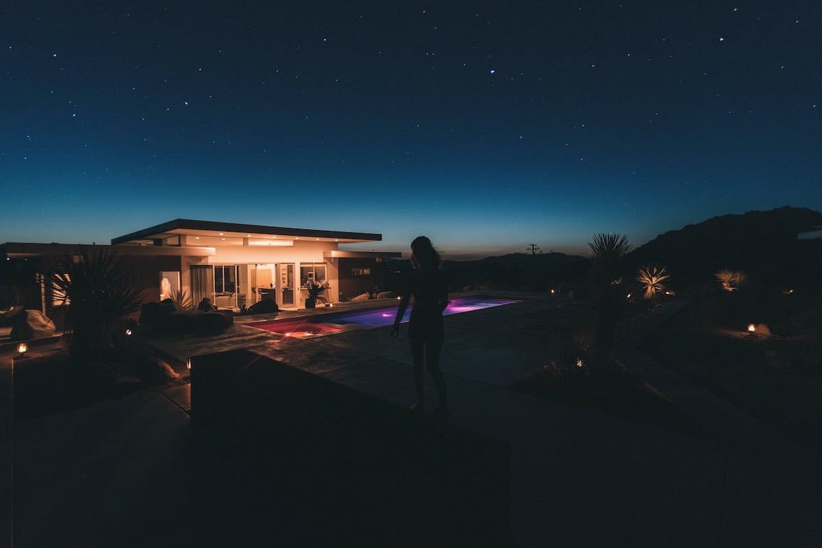 Night falls over Joshua Tree, California. Lighted pool in different colors with beautiful sky.