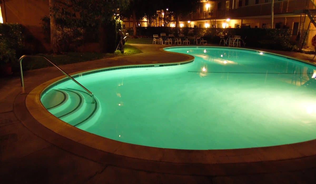 An apartment pool at night. Water looks green due to the lightning in the pool. Photo by: Jovas.